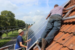 Steffen Kapelle und Frank Lehmann montieren die Solarmodule auf dem Dach von Günter Jurischka und Steffen Kapelle in Proschim.