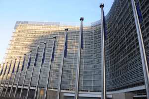 EU Regierungsgebäude in Brüssel. Davor weht die Europa-Fahne.