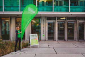Eine Frau mit einem Green Planet Energy Aufsteller vor der Heinrich-Böll-Stiftung in Berlin.