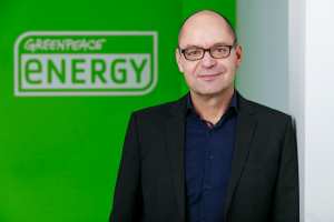 Marcel Keiffenheim vor einem grünen Greenpeace Energy Logo