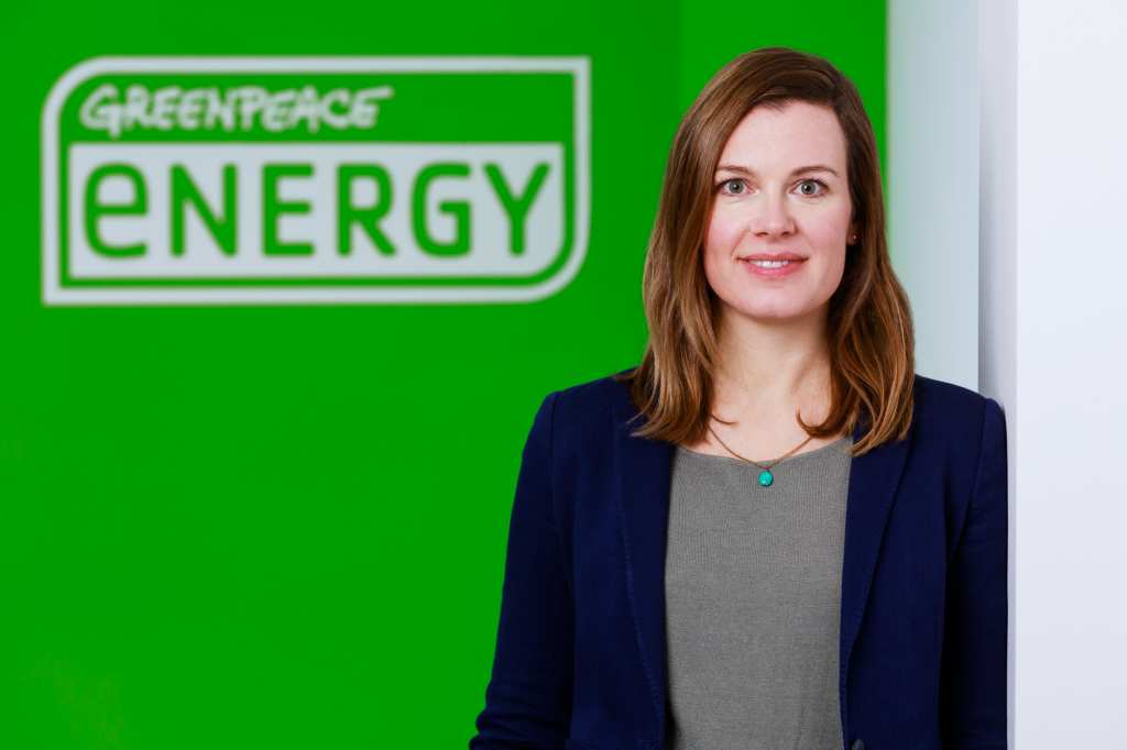 Ariane August steht vor Greenpeace Energy Logo